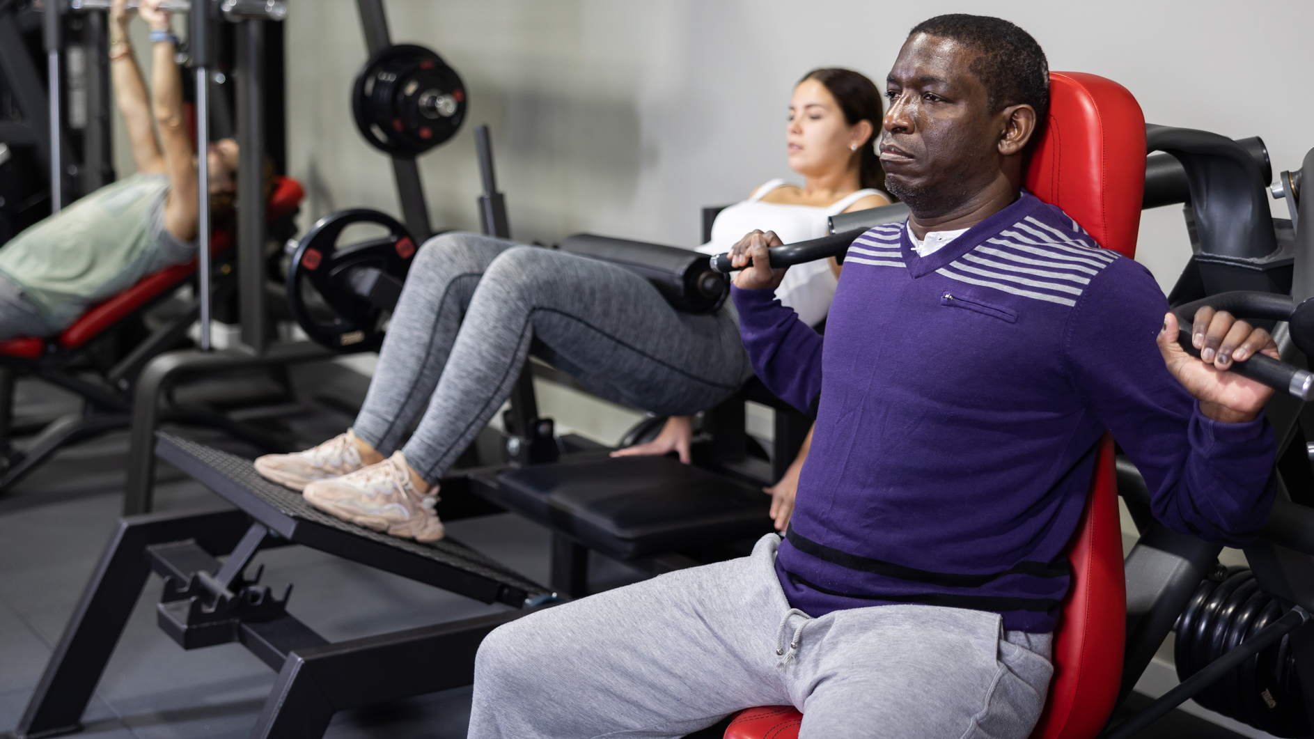 Man exercises on the shoulder press machine