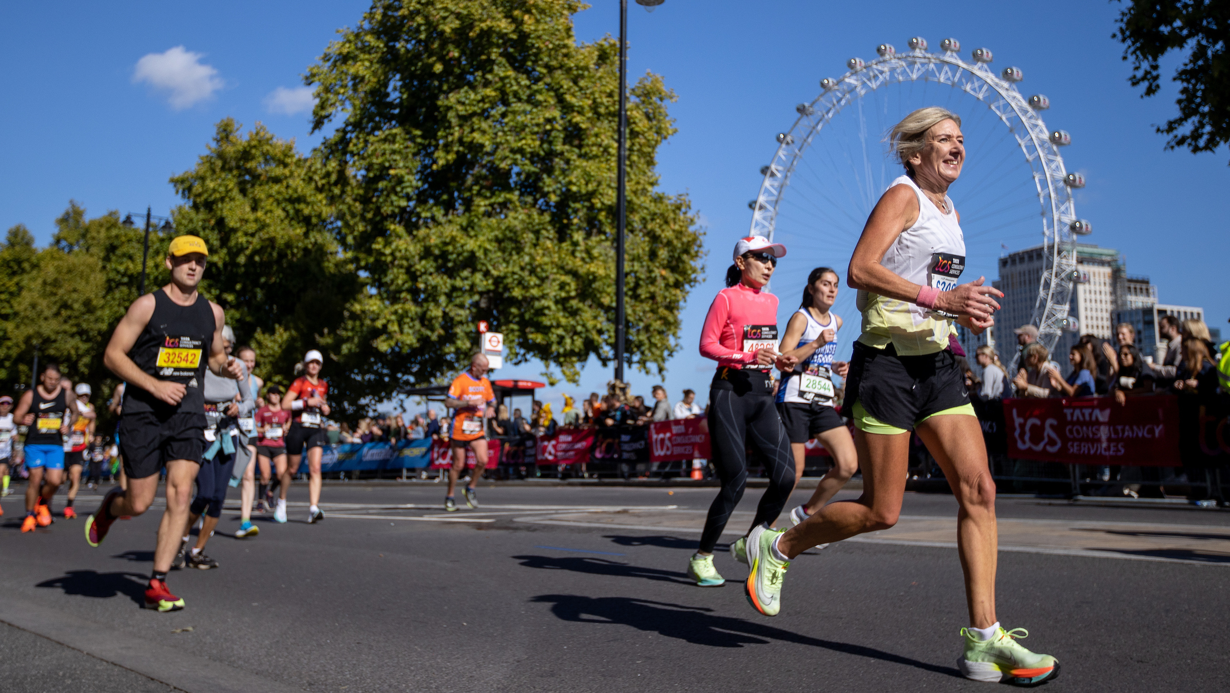 Runners in the London Marathon on the Embankment in Westminster. The Millennium Wheel is in the background